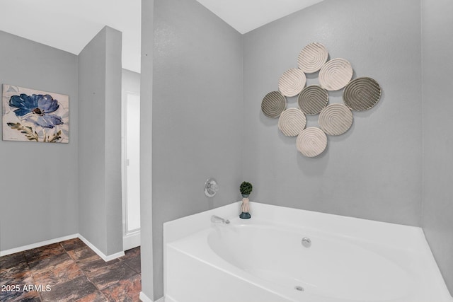 1314 S Bridgegate Dr, Gilbert, AZ 85296 - bathroom with a bath, baseboards, and stone finish floors