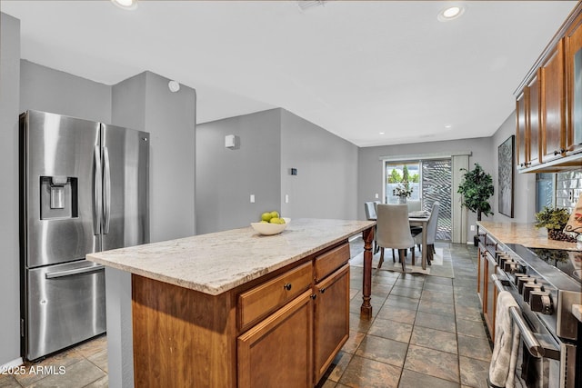 1314 S Bridgegate Dr, Gilbert, AZ 85296 - kitchen with appliances with stainless steel finishes, stone tile flooring, a center island, light stone countertops, and brown cabinets