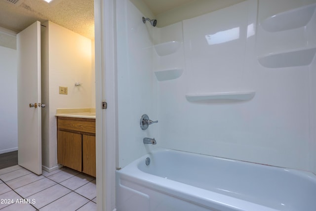 bathroom featuring tile patterned floors, vanity, a textured ceiling, and bathtub / shower combination