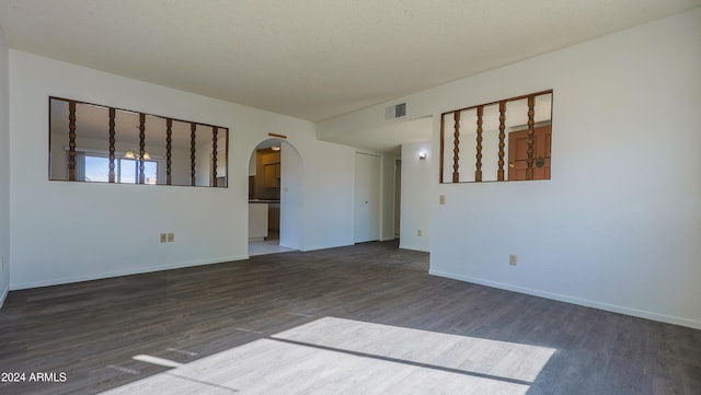 unfurnished room with a textured ceiling and dark hardwood / wood-style floors