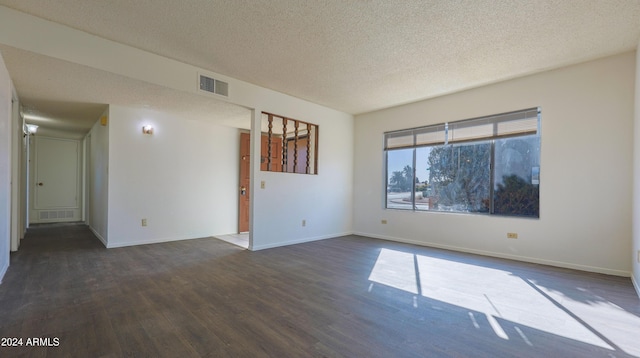 empty room featuring a textured ceiling and dark hardwood / wood-style floors