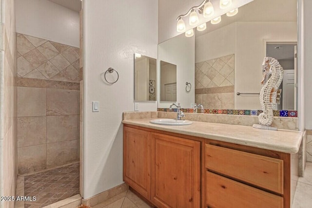 bathroom featuring tile patterned flooring, vanity, and tiled shower