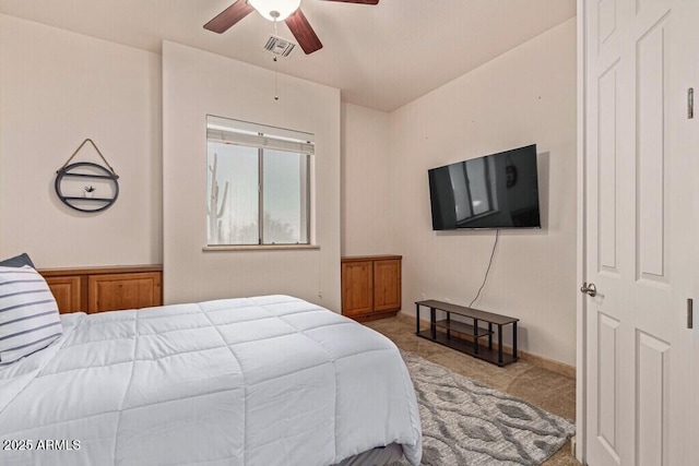 carpeted bedroom featuring a ceiling fan and visible vents
