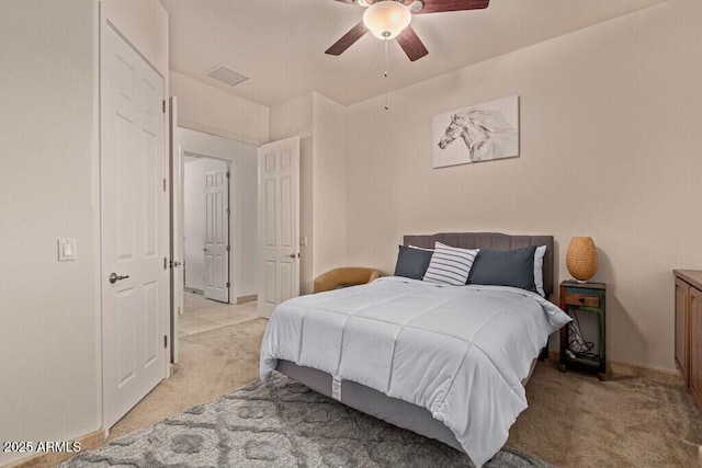 bedroom with a ceiling fan, light carpet, and baseboards