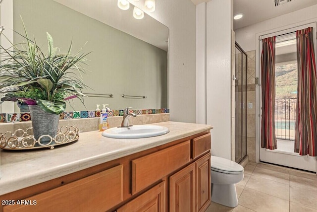 bathroom with toilet, vanity, visible vents, a stall shower, and tile patterned flooring