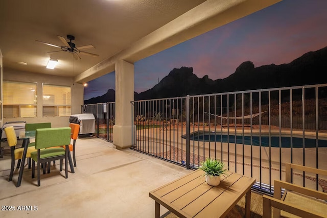 view of patio / terrace with outdoor dining area, fence, a fenced in pool, and ceiling fan