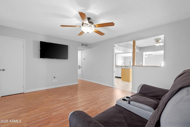 1604 W Kerry Ln, Phoenix, AZ 85027 - living area featuring visible vents, baseboards, ceiling fan, light wood-style flooring, and a textured ceiling