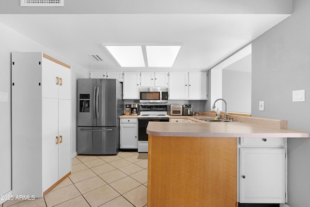 1604 W Kerry Ln, Phoenix, AZ 85027 - kitchen with a peninsula, a sink, stainless steel appliances, light countertops, and white cabinets