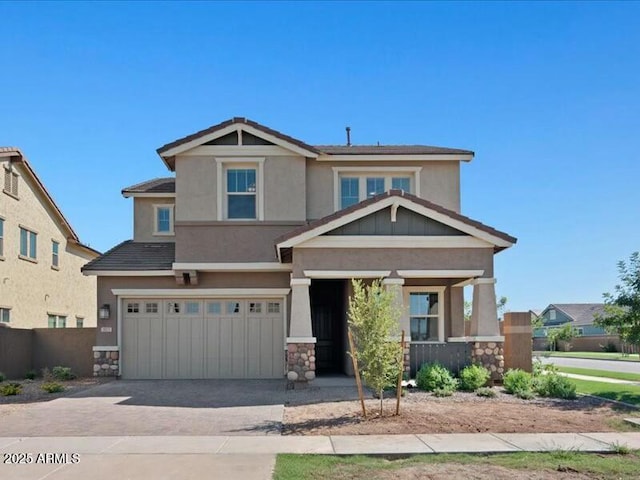 craftsman inspired home featuring a garage, concrete driveway, stone siding, and stucco siding