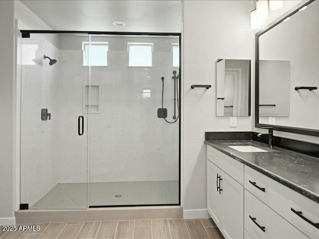 bathroom with a shower stall and vanity