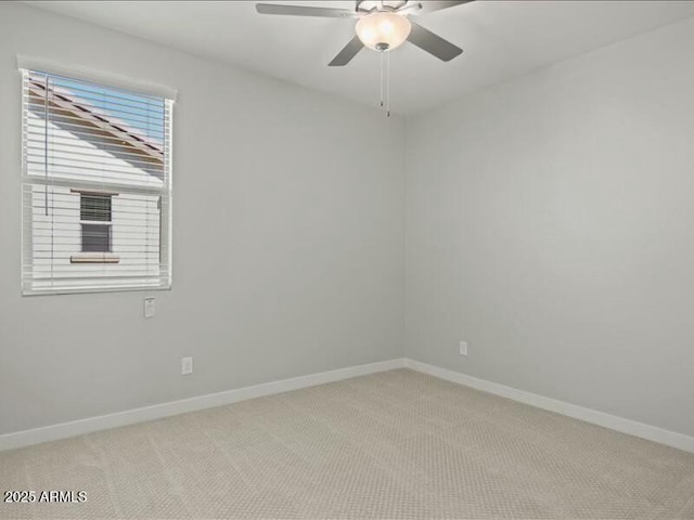 spare room featuring ceiling fan, baseboards, and light colored carpet