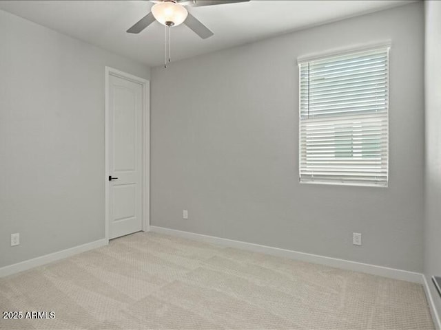 unfurnished room featuring light carpet, a ceiling fan, and baseboards