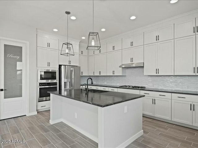 kitchen with decorative backsplash, appliances with stainless steel finishes, under cabinet range hood, white cabinetry, and a sink