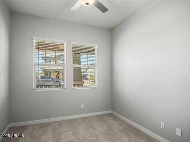 spare room with carpet, ceiling fan, and baseboards