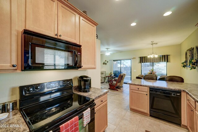 kitchen featuring light stone counters, decorative light fixtures, light brown cabinetry, black appliances, and ceiling fan with notable chandelier