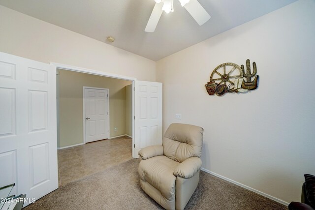 living area with carpet and ceiling fan