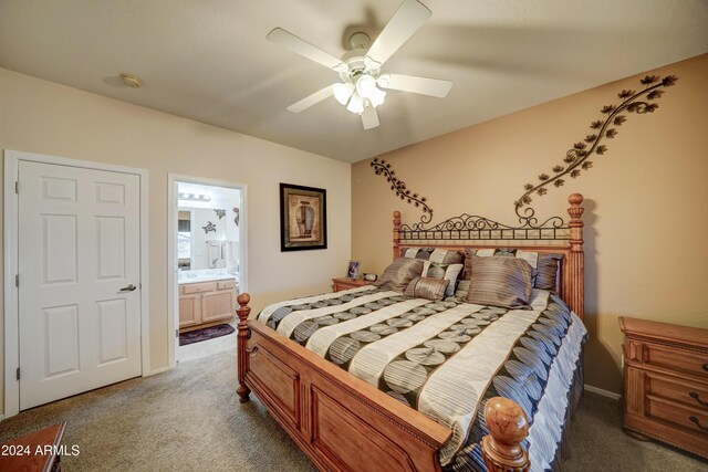 carpeted bedroom with ensuite bathroom and ceiling fan