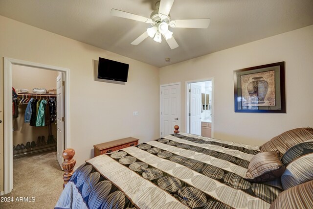 bedroom featuring light carpet, ensuite bathroom, ceiling fan, a spacious closet, and a closet