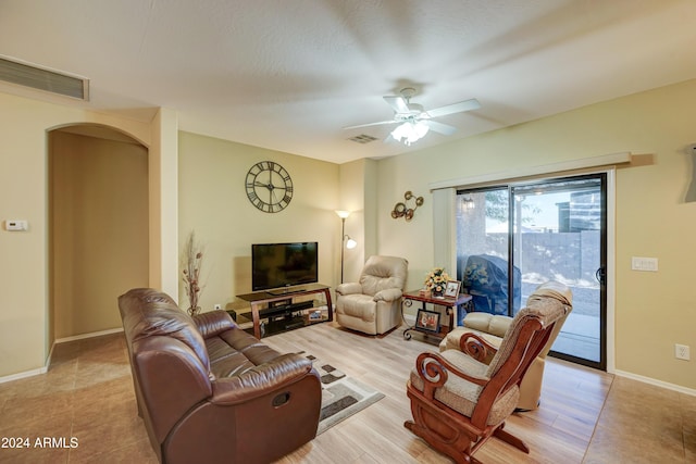 living room with ceiling fan, a textured ceiling, and light hardwood / wood-style flooring