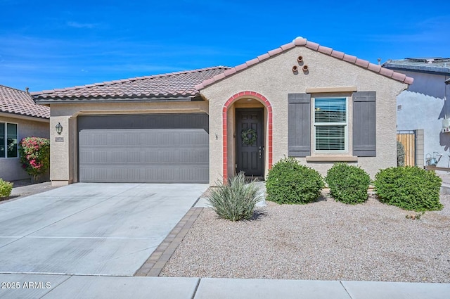 mediterranean / spanish-style house featuring a tile roof, driveway, an attached garage, and stucco siding