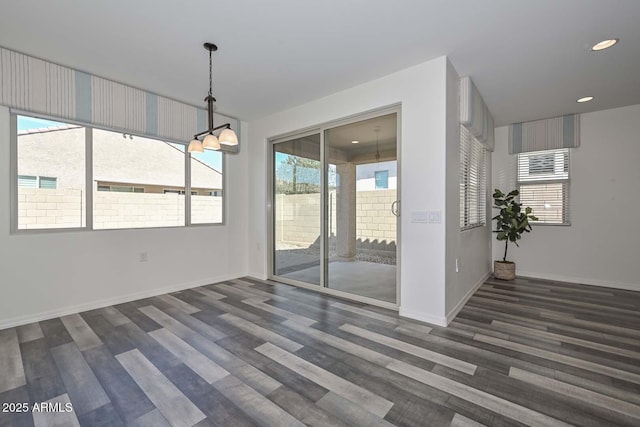 unfurnished dining area featuring recessed lighting, baseboards, and wood finished floors