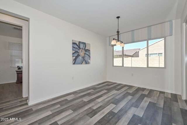 unfurnished dining area featuring visible vents, dark wood finished floors, a notable chandelier, and baseboards