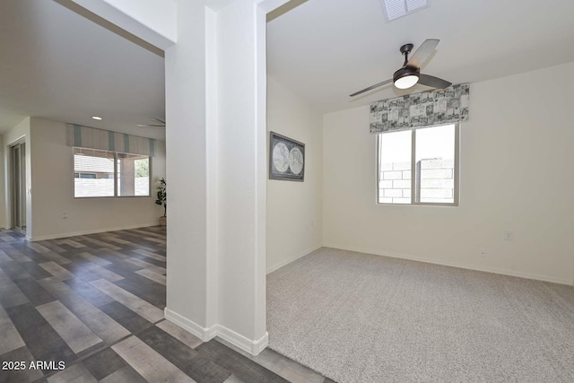 empty room with baseboards, visible vents, and a ceiling fan