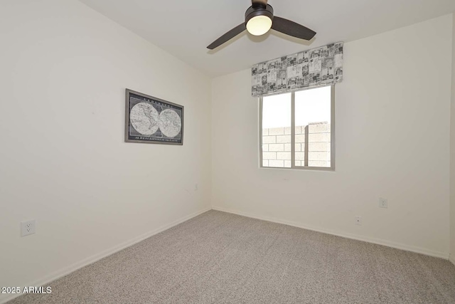 spare room with carpet flooring, a ceiling fan, and baseboards