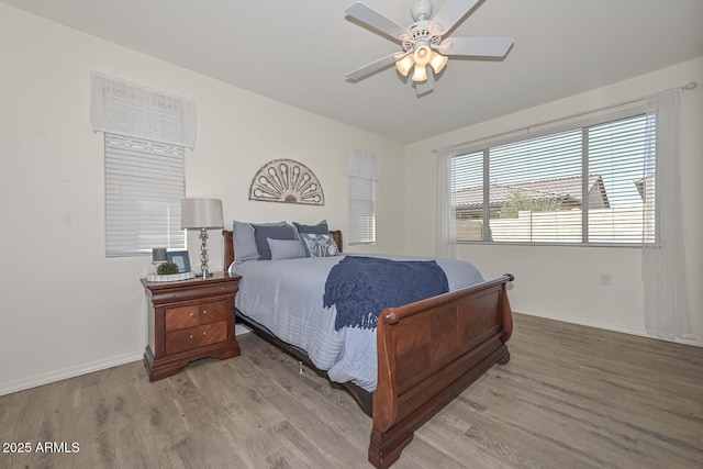 bedroom featuring light wood-style flooring, baseboards, and a ceiling fan