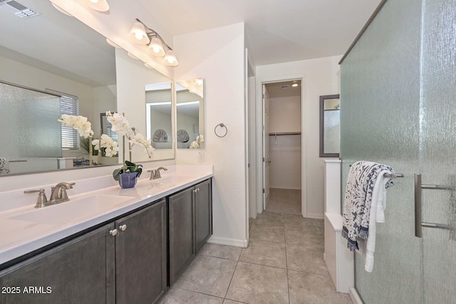 bathroom featuring double vanity, tile patterned flooring, visible vents, and a sink