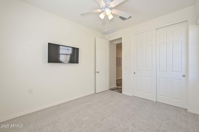 unfurnished bedroom featuring a closet, carpet, visible vents, and baseboards