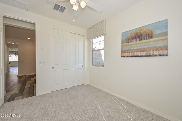 unfurnished bedroom featuring carpet floors, a closet, visible vents, and baseboards