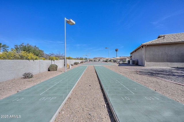 view of home's community featuring shuffleboard and fence