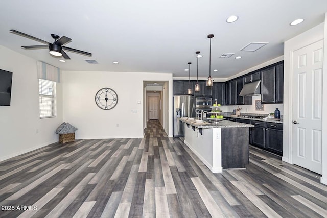 kitchen featuring open floor plan, appliances with stainless steel finishes, visible vents, and under cabinet range hood