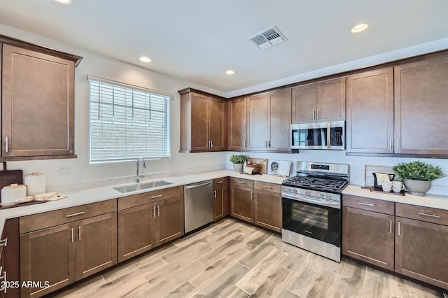 3339 S Lily Ave, Mesa, AZ 85212 - kitchen with appliances with stainless steel finishes, a sink, light countertops, recessed lighting, and light wood-style flooring