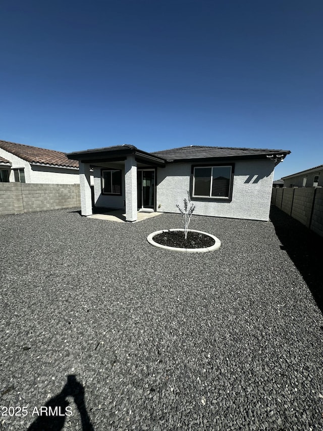 exterior space featuring a fenced backyard and stucco siding