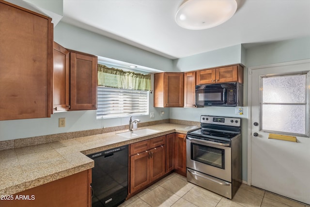 kitchen with a sink, black appliances, tile counters, and brown cabinetry