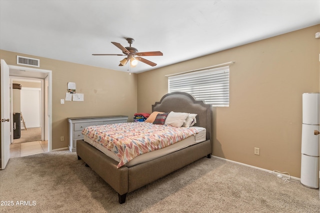 bedroom with a ceiling fan, light colored carpet, visible vents, and baseboards