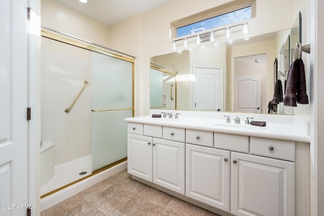 bathroom featuring a shower with door and vanity