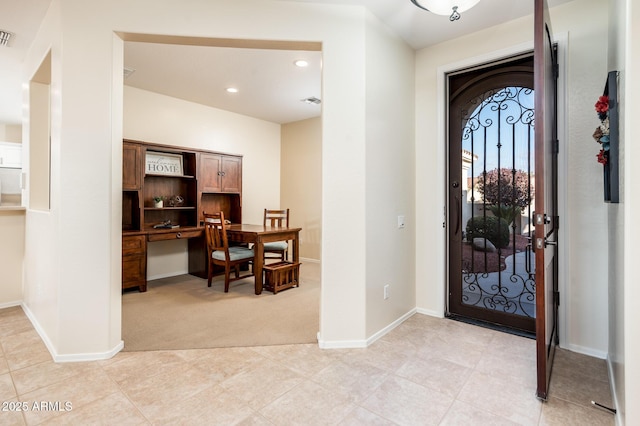 carpeted entryway featuring built in desk