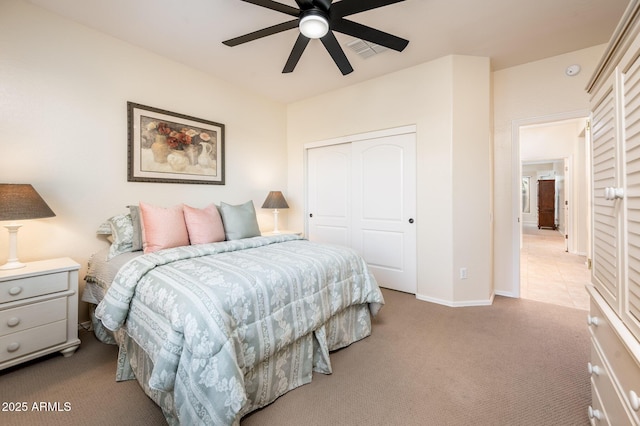 carpeted bedroom with ceiling fan and a closet