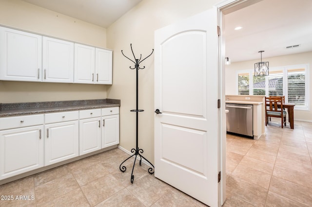 clothes washing area with light tile patterned floors and a chandelier