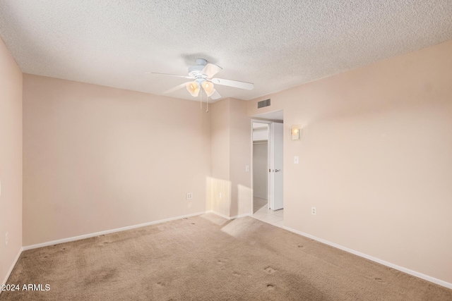 unfurnished room with light carpet, a textured ceiling, and ceiling fan