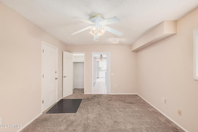 carpeted empty room featuring a textured ceiling and ceiling fan