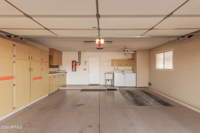 garage featuring ceiling fan, independent washer and dryer, and sink