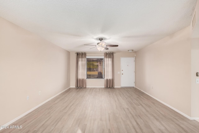 unfurnished living room with ceiling fan, a textured ceiling, and light hardwood / wood-style flooring