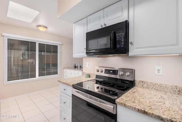 kitchen with white cabinetry, light tile patterned flooring, light stone countertops, and stainless steel range with electric stovetop