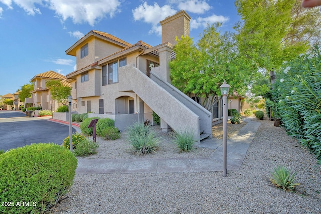 1211 N Miller Rd Unit 257, Scottsdale, AZ 85257 - view of front of property featuring stucco siding, a chimney, and a tiled roof