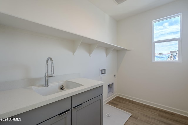 laundry room featuring wood-type flooring, sink, cabinets, washer hookup, and hookup for an electric dryer