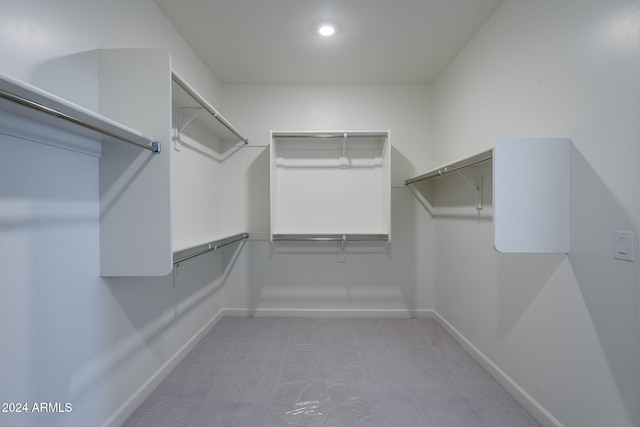 walk in closet featuring light colored carpet